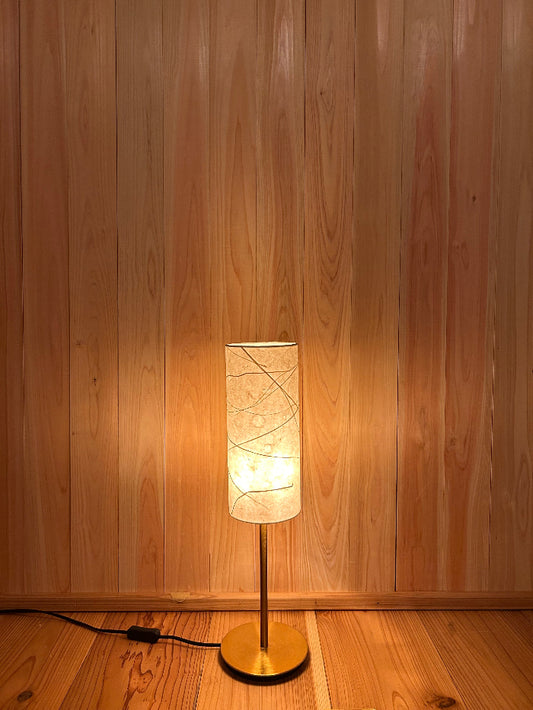 washi lamp with a warm light on a wooden wall
