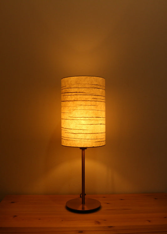 Handmade Washi Lamp on a wooden table, creating a soft and warm light in room