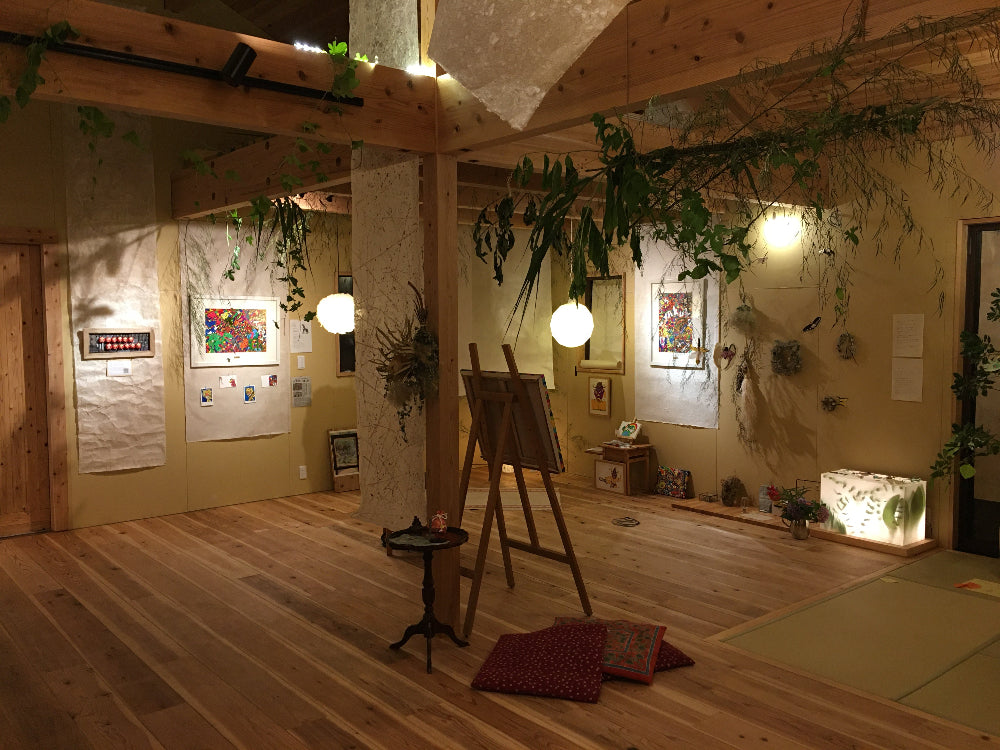 Wa Art Exhibition at night, with washi lamps, wall panels, and tapestries.