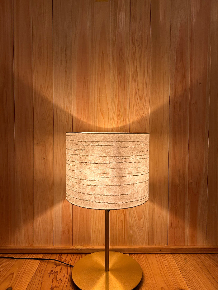 Floor lamp with washi shade on a wooden floor.  soft warm glow