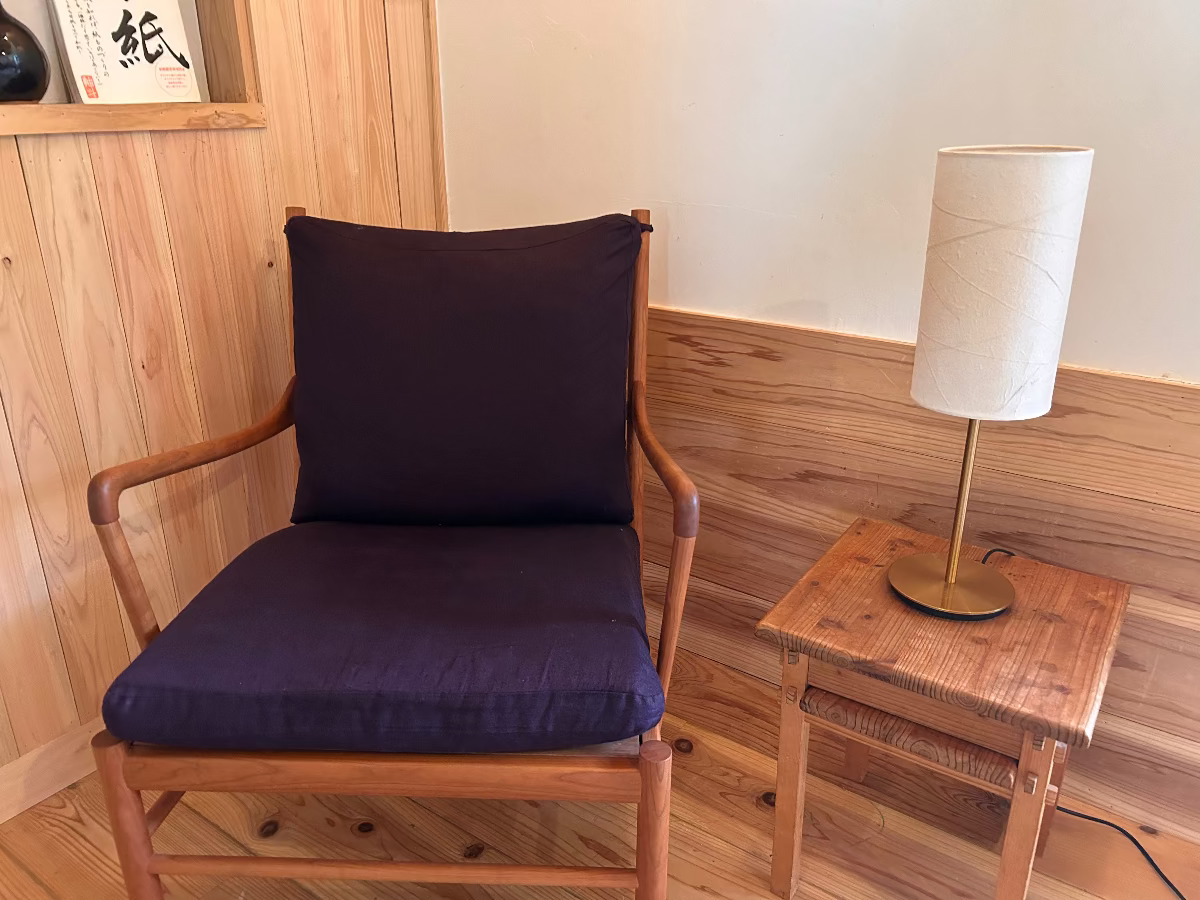 Table lamp with handmade japanese paper lampshade sitting next to a wooden chair, the light is off